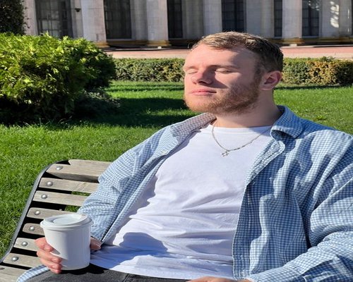 A relaxed man standing outdoors taking a short break from his daily work routine